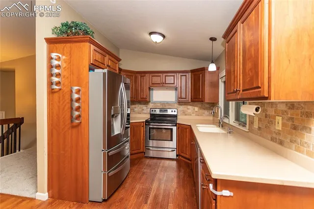 a kitchen with stainless steel appliances kitchen island granite countertop a table chairs and a stove