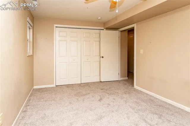 an empty room with a window and a fan