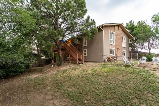 a backyard of a house with wooden stairs and trees
