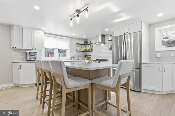 a dining room with stainless steel appliances kitchen island granite countertop a dining table chairs and view living room