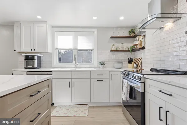 a kitchen with granite countertop white cabinets white stainless steel appliances with a sink and dishwasher