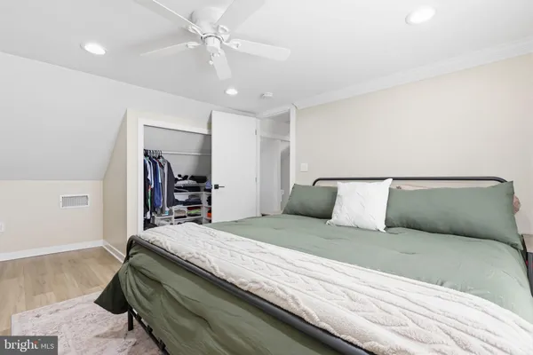 a bedroom with a large bed and a chandelier