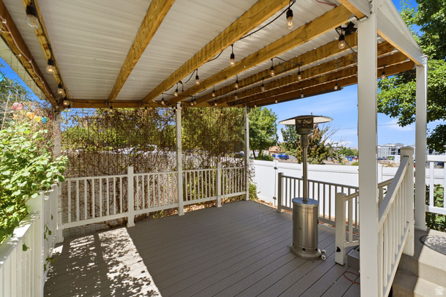 1925 South Main Street Bountiful, UT 84010 - Photo 35 of 48 Covered outdoor deck featuring composite decking, white railing, exposed wood beams, and a corrugated metal ceiling