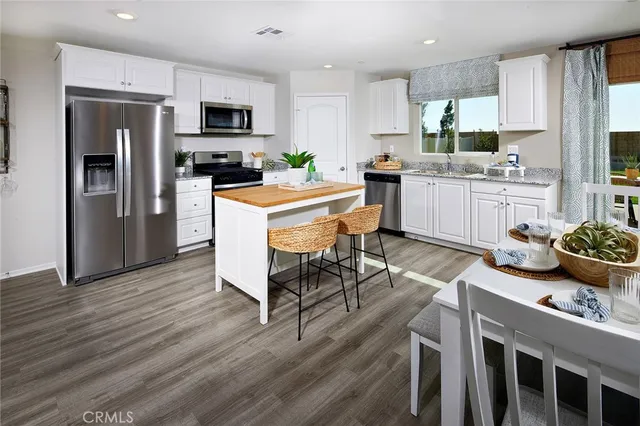 a kitchen with granite countertop kitchen island wooden cabinets and stainless steel appliances