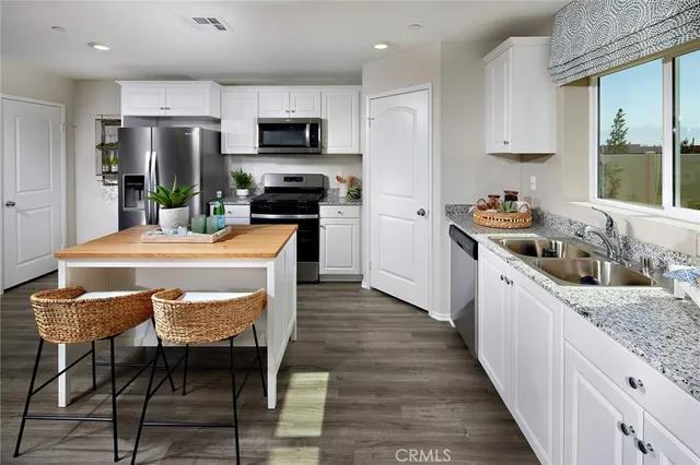 a kitchen with stainless steel appliances kitchen island granite countertop a stove a sink and a microwave