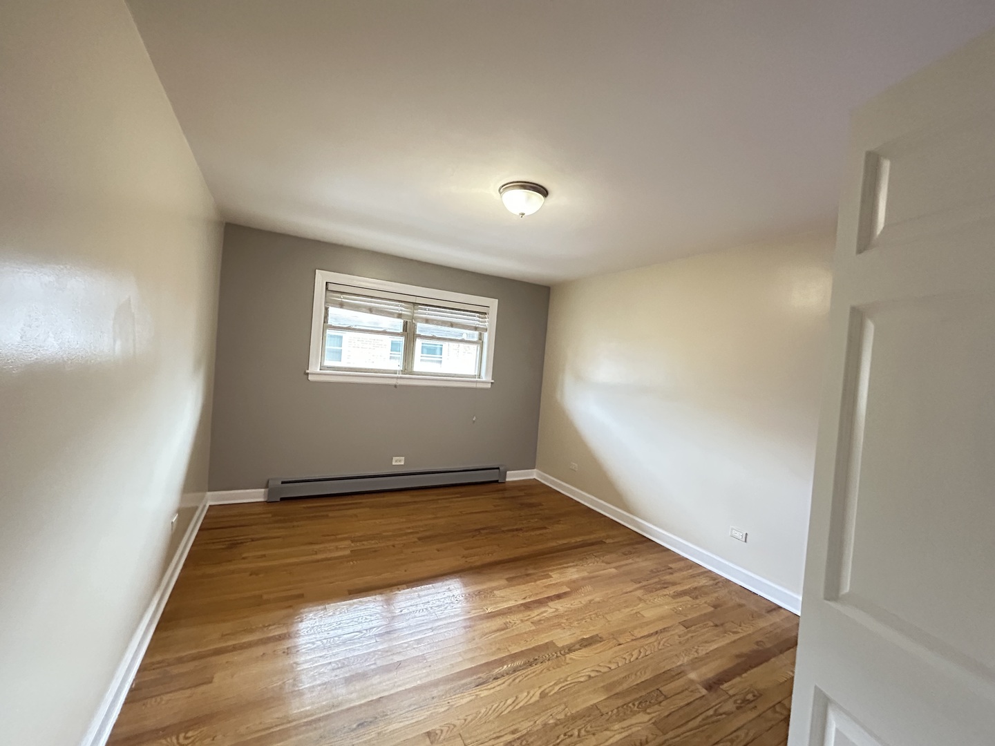 4342 North Kedvale Avenue, Unit 2A Chicago, IL 60641 - Photo 5 of 23 an empty room with wooden floor and windows