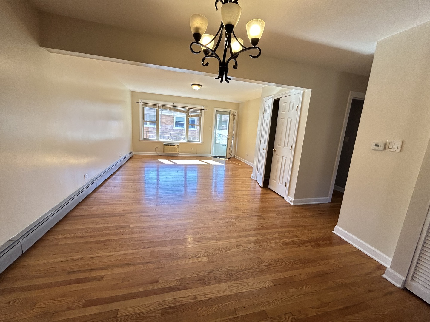 4342 North Kedvale Avenue, Unit 2A Chicago, IL 60641 - Photo 8 of 23 a view of an empty room with wooden floor and a window