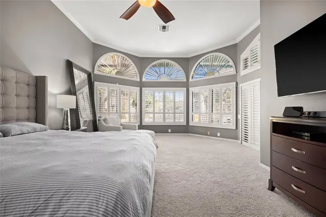 a large bedroom with a large bed and a tv on dresser