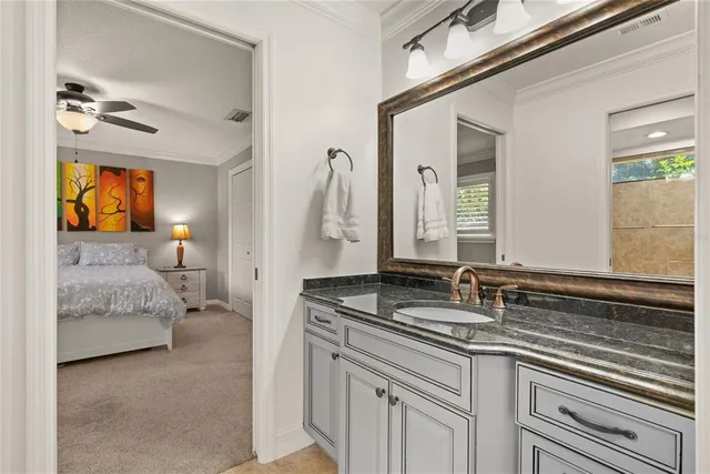 a en suite bathroom with a granite countertop sink and a mirror