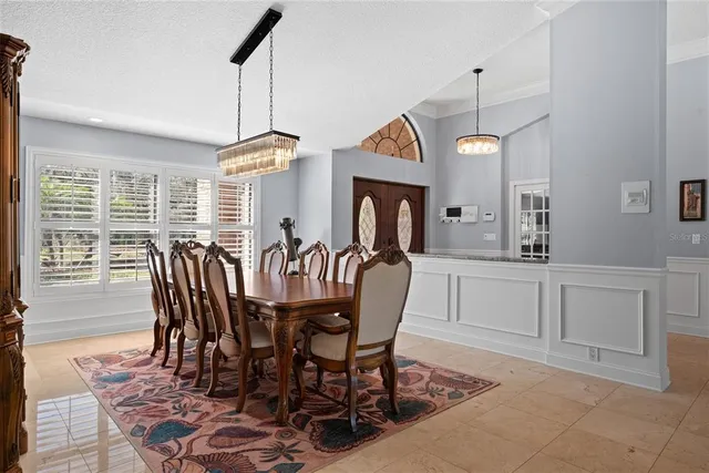 a dining room with furniture a chandelier and window