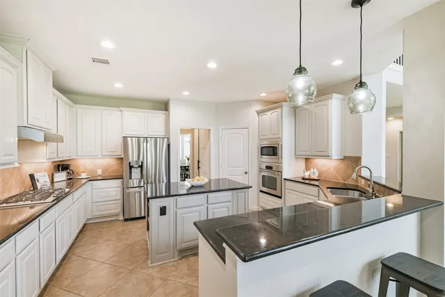 a kitchen with stainless steel appliances a sink stove and refrigerator