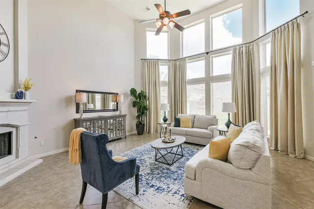 a living room with furniture a flat screen tv and a large window
