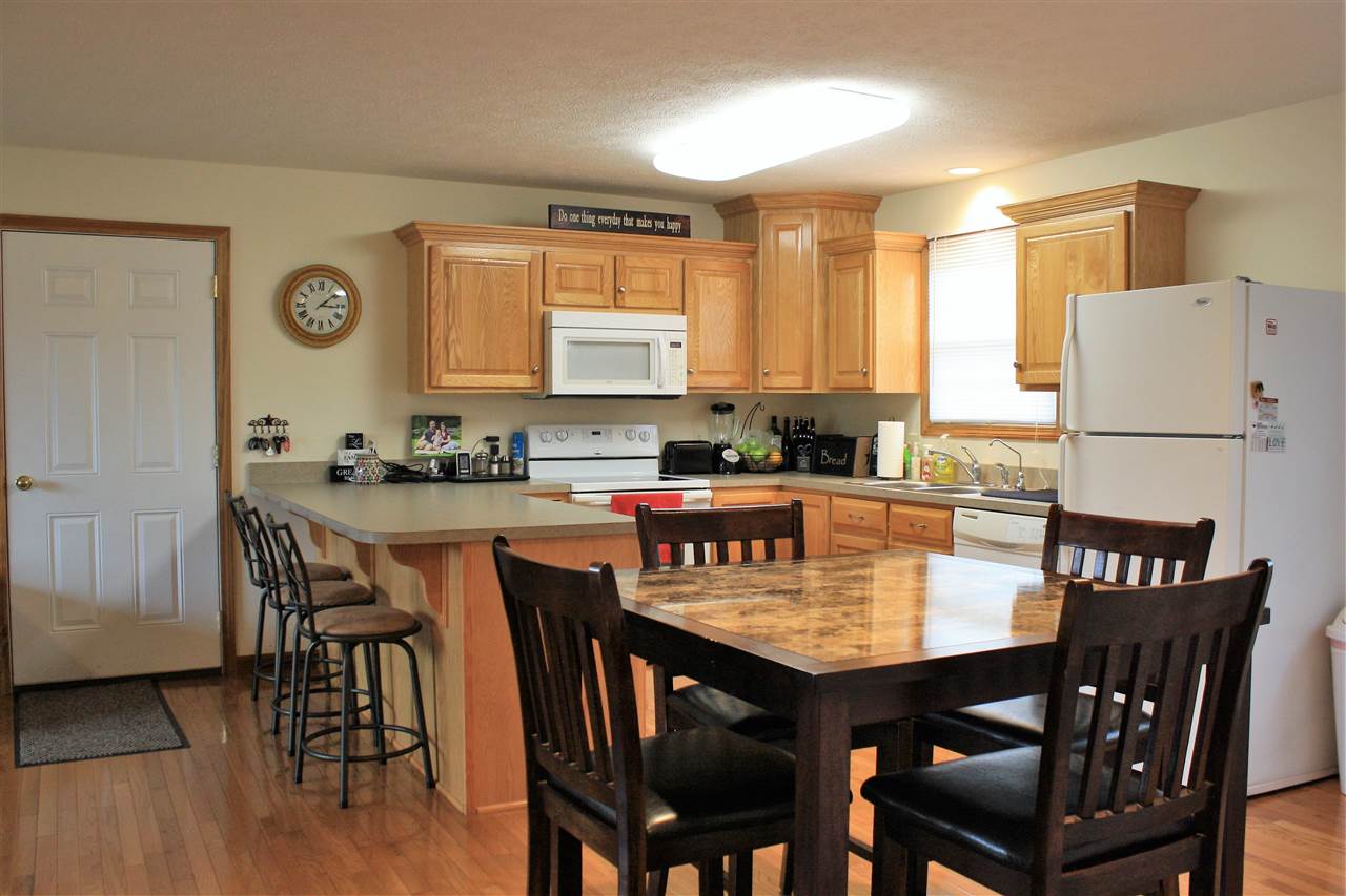 824 Mt Solon Road Mount Solon, VA 22843 - Photo 8 of 15 a kitchen with granite countertop a dining table chairs and white cabinets