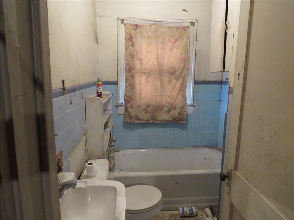 3638 Cleveland Street Dallas, TX 75215 - Photo 11 of 12 a bathroom with a granite countertop bathtub shower sink vanity and toilet