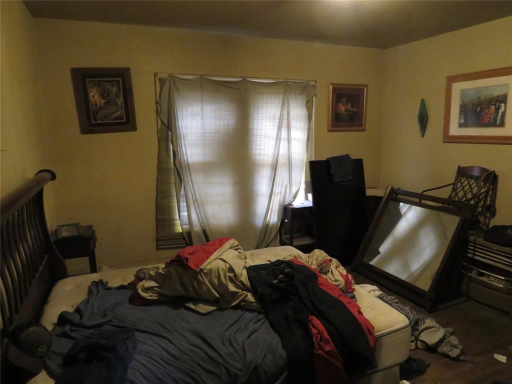 3638 Cleveland Street Dallas, TX 75215 - Photo 2 of 12 a bedroom with a bed and wooden floor