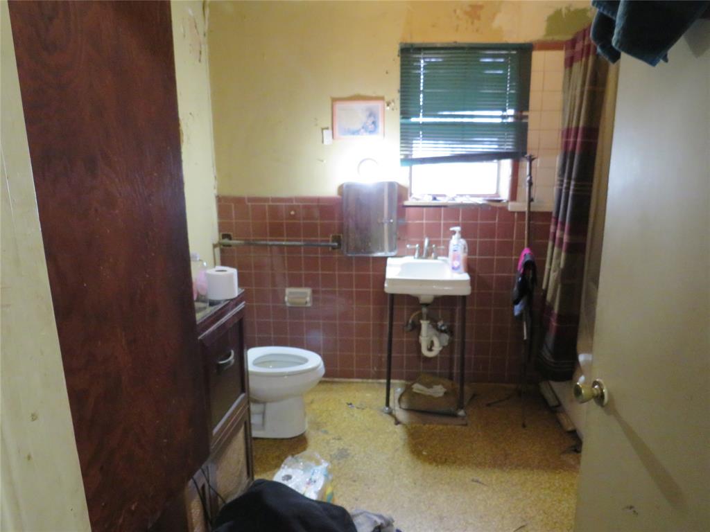 3638 Cleveland Street Dallas, TX 75215 - Photo 6 of 12 a bathroom with a sink toilet and mirror