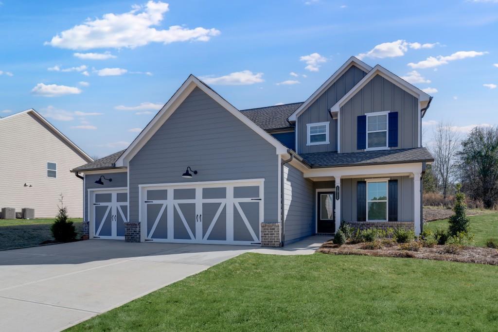 1011 Reagan Drive Madison, GA 30650 - Photo 2 of 40 a front view of a house with a yard and garage