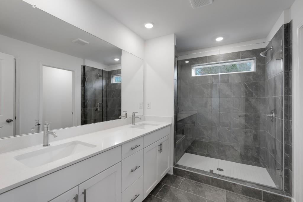 1011 Reagan Drive Madison, GA 30650 - Photo 31 of 40 a bathroom with a shower sink and mirror