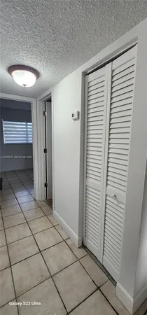 a view of hallway with a table and a chandelier