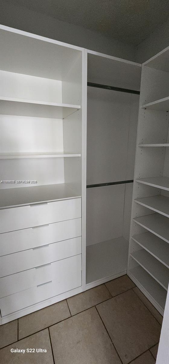 11321 Southwest 65th Street Miami, FL 33173 - Photo 17 of 24 a view of walk in closet with empty racks