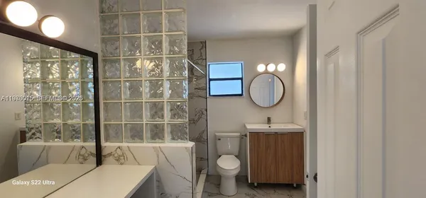 wooden floor in an empty room with a bathroom