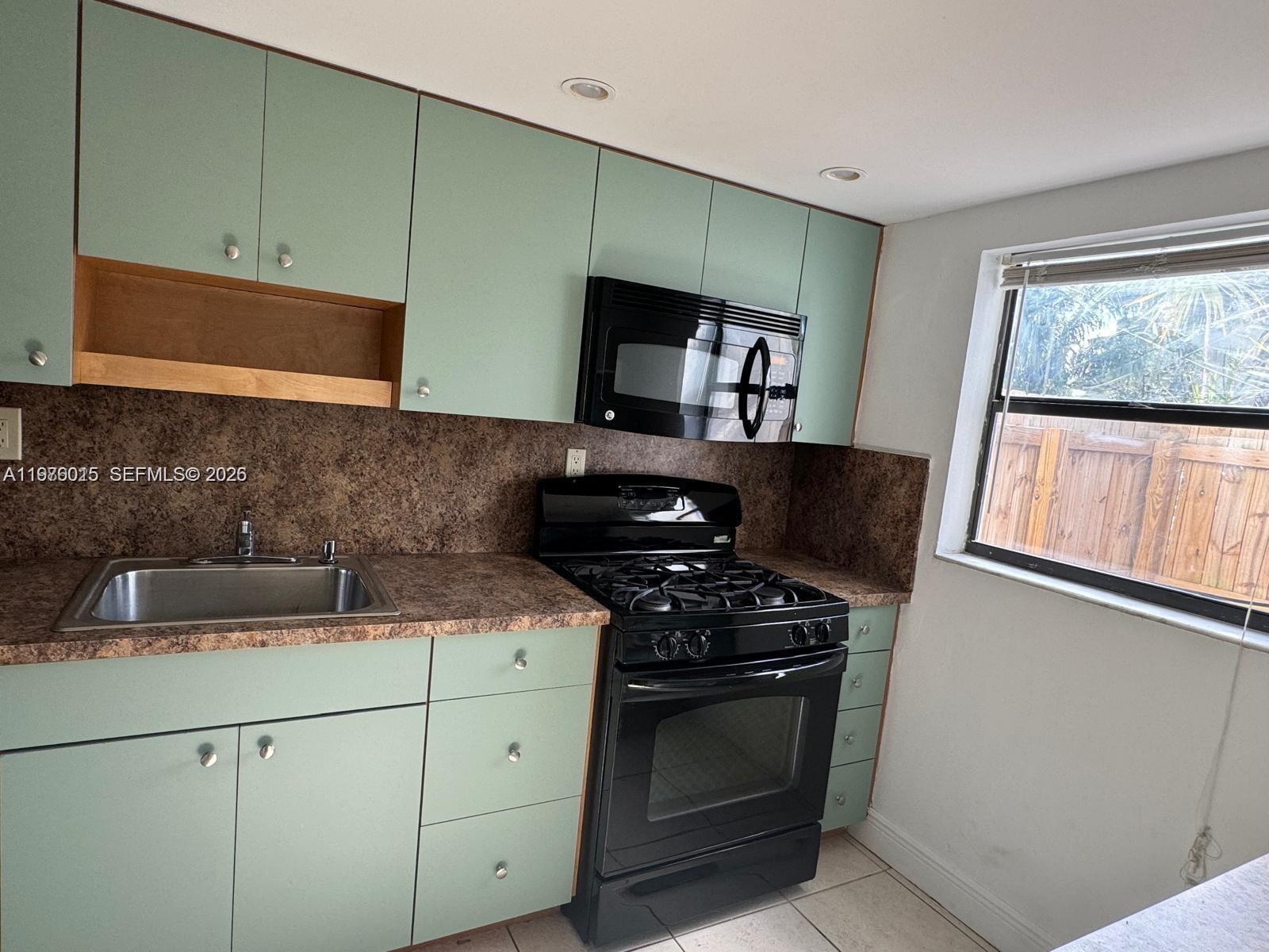 11321 Southwest 65th Street Miami, FL 33173 - Photo 3 of 24 a kitchen with a stove and a microwave