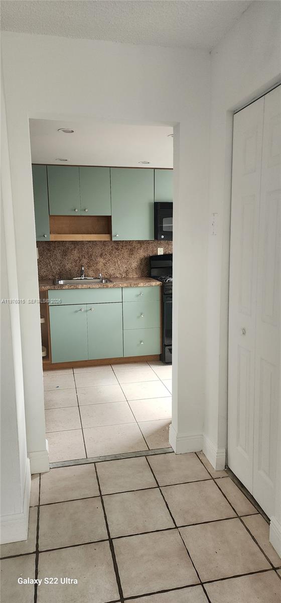 11321 Southwest 65th Street Miami, FL 33173 - Photo 6 of 24 a kitchen with a stove top oven and cabinets