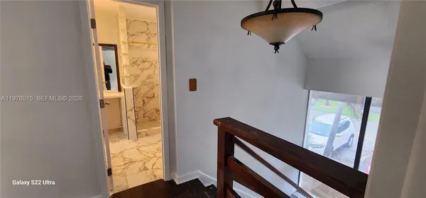 a view of hallway with a table and a chandelier