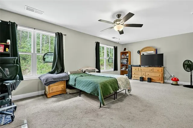 a spacious bedroom with a bed and ceiling fan