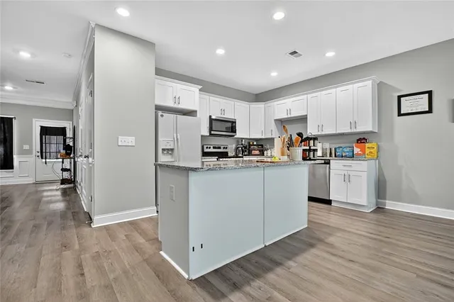 a kitchen with white cabinets and refrigerator