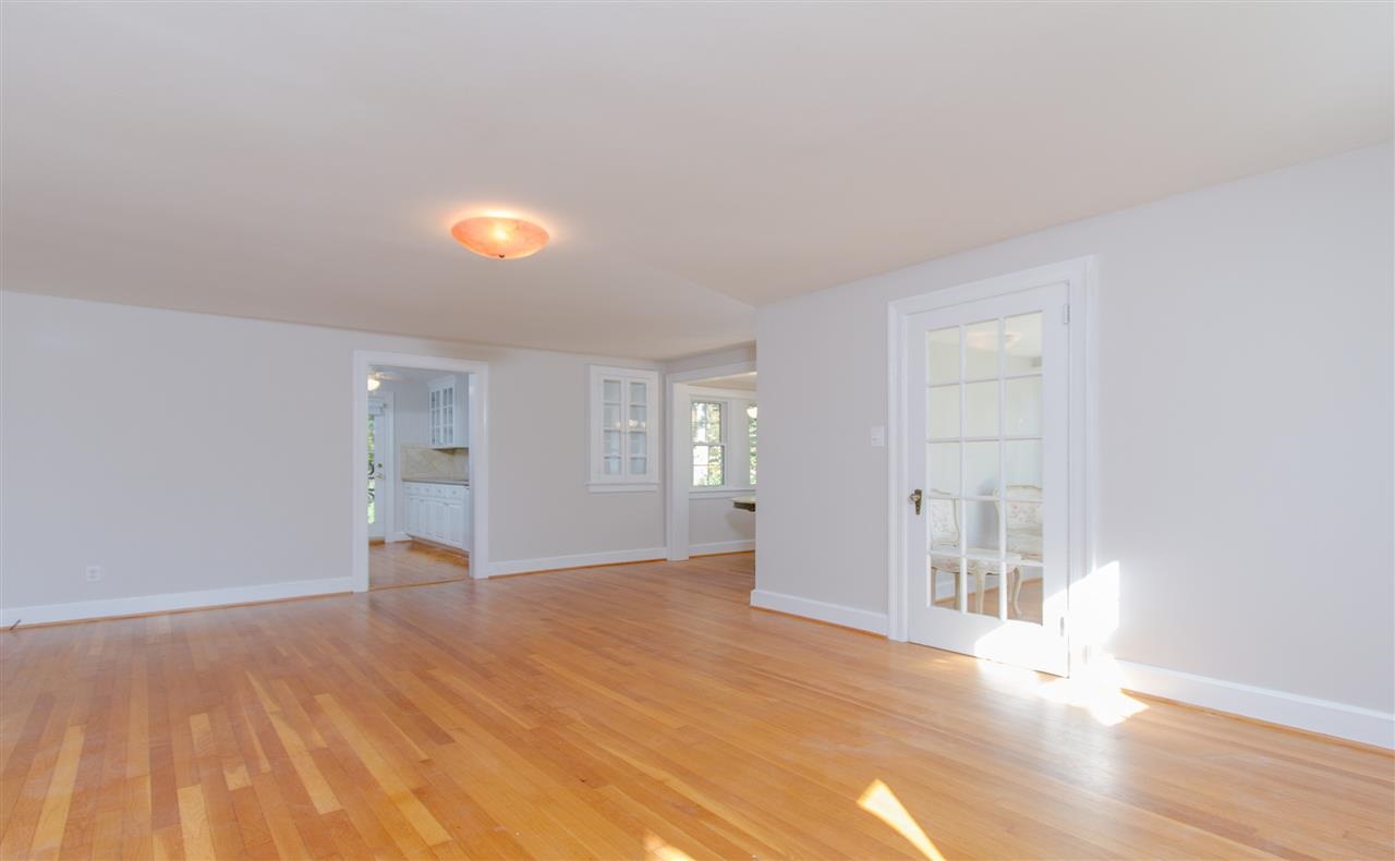 400 Perry Street Raleigh, NC 27608 - Photo 4 of 22 a view of an empty room with wooden floor and a window