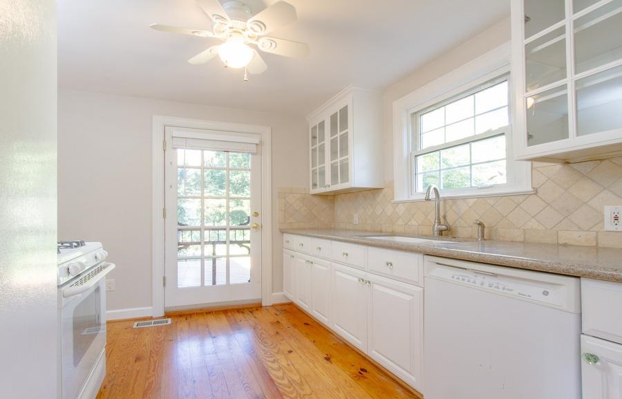 400 Perry Street Raleigh, NC 27608 - Photo 6 of 22 a kitchen with a sink window and cabinets