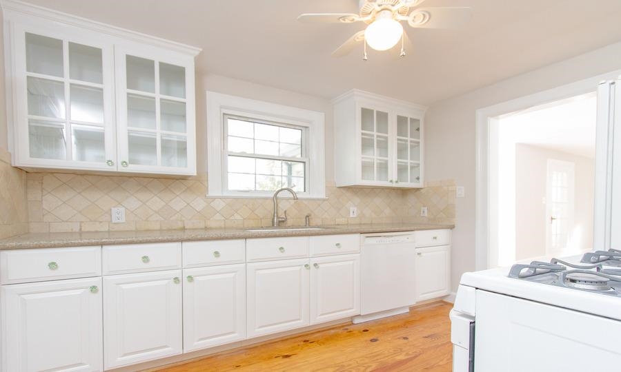 400 Perry Street Raleigh, NC 27608 - Photo 7 of 22 a kitchen with granite countertop white cabinets and white appliances