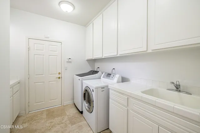 a utility room with sink dryer and washer