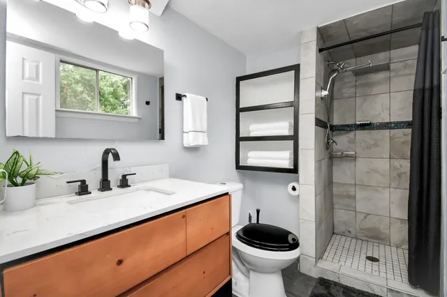 a bathroom with a sink a toilet and shower