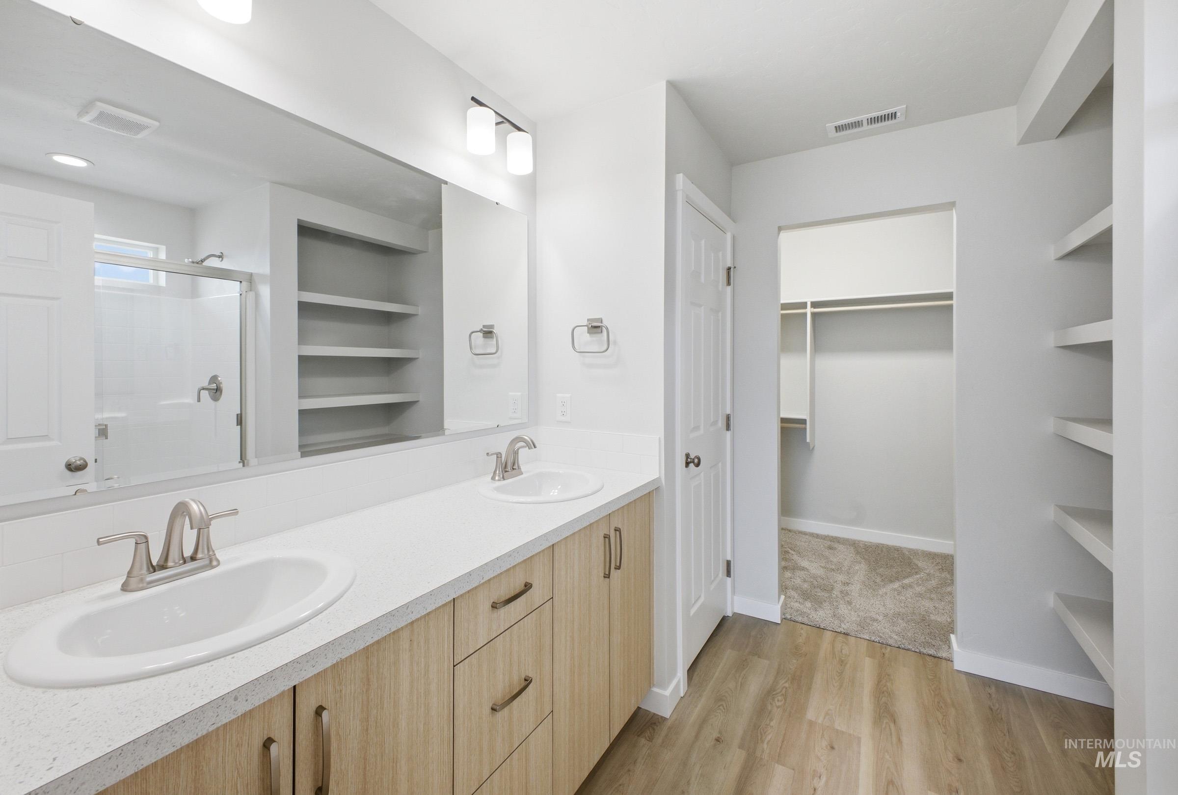 1598 Sunday River Street Middleton, ID 83644 - Photo 16 of 17 Bathroom featuring a dual-sink vanity with wood-finish cabinetry and light-colored countertops