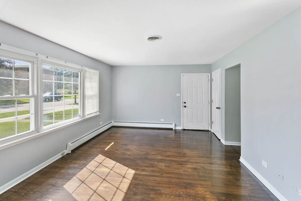 11212 1st Street, Unit 1 Mokena, IL 60448 - Photo 7 of 10 a view of an empty room with wooden floor and a window