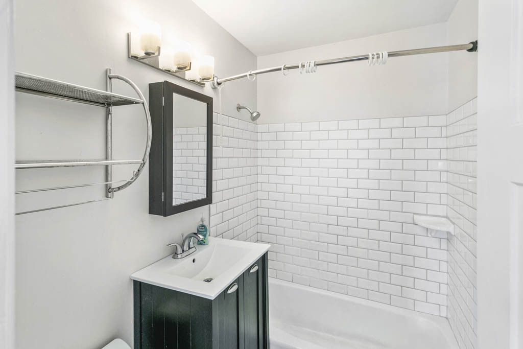 11212 1st Street, Unit 1 Mokena, IL 60448 - Photo 8 of 10 a bathroom with a sink mirror and shower