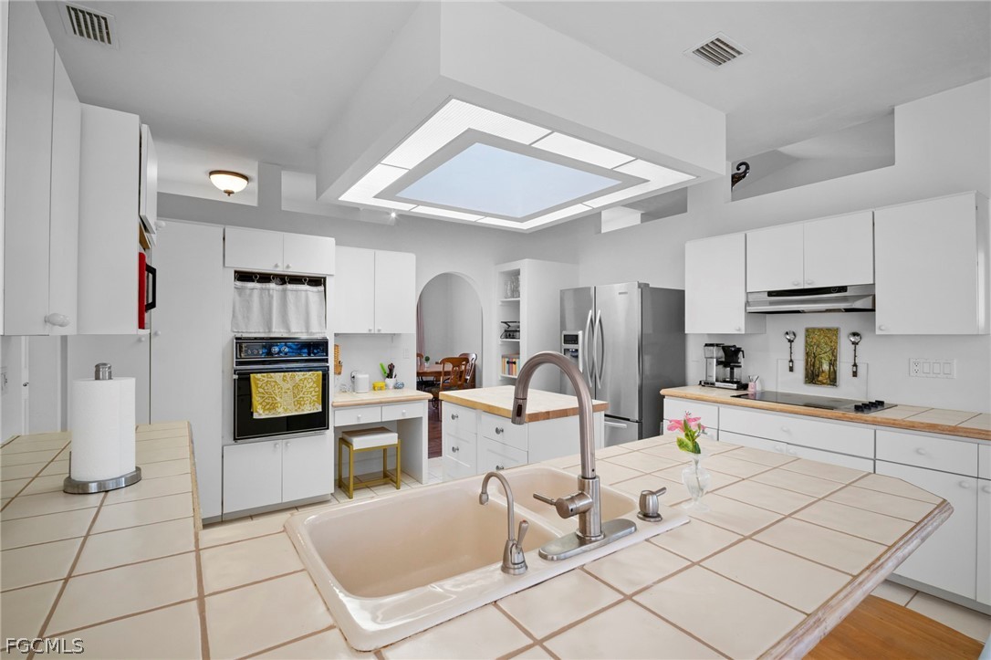 11772 Mahogany Run Fort Myers, FL 33913 - Photo 19 of 50 a kitchen with stainless steel appliances kitchen island granite countertop a refrigerator and a stove top oven