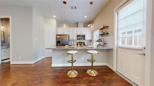 a view of an empty room with window and wooden floor