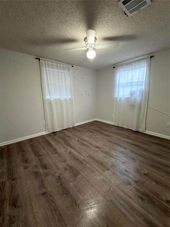 2426 May Lane Grand Prairie, TX 75050 - Photo 11 of 20 an empty room with wooden floor and windows