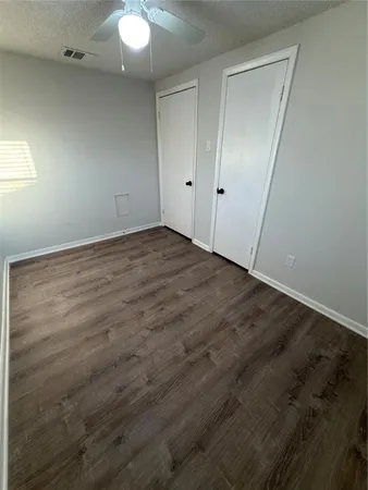 an empty room with wooden floor and white cabinet