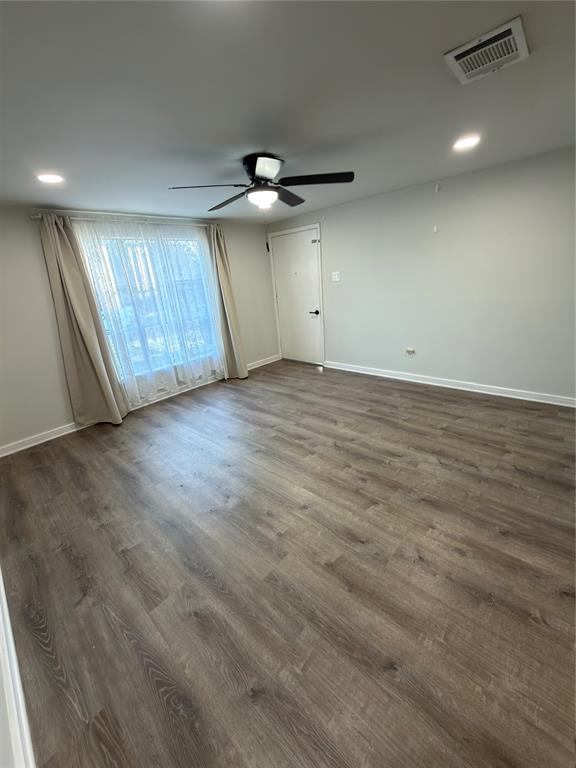 2426 May Lane Grand Prairie, TX 75050 - Photo 4 of 20 an empty room with wooden floor ceiling fan and windows
