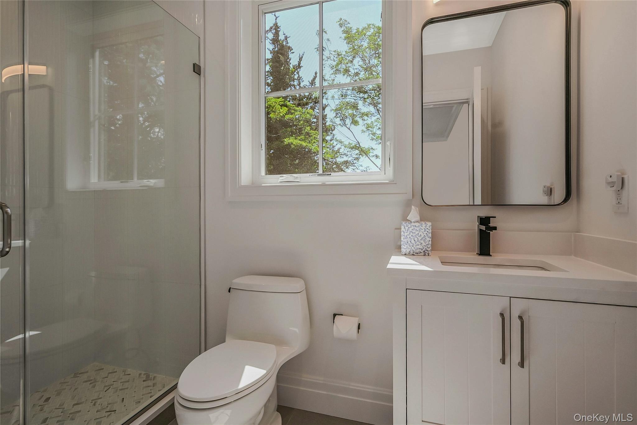 1665 Glenn Road Southold, NY 11971 - Photo 25 of 34 a bathroom with a toilet a sink a vanity and mirror