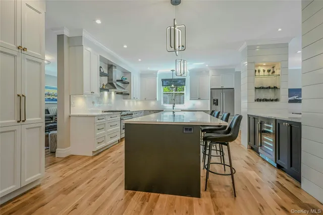 a kitchen with stainless steel appliances kitchen island granite countertop wooden floors and wooden cabinets