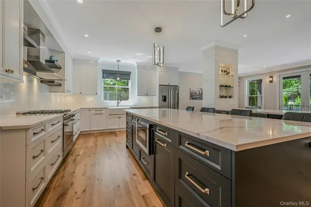 a large kitchen with stainless steel appliances granite countertop a sink stove and refrigerator
