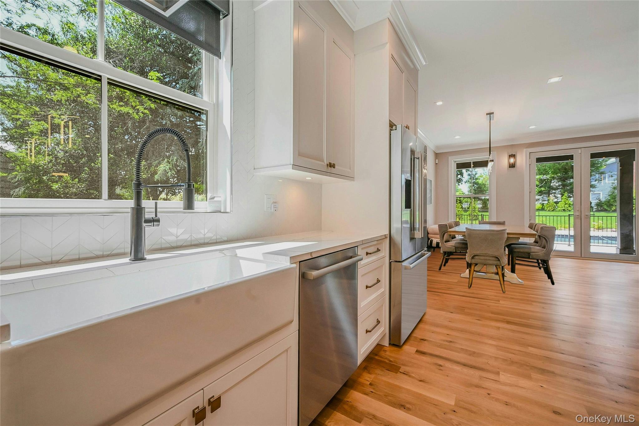 1665 Glenn Road Southold, NY 11971 - Photo 9 of 34 an open kitchen with granite countertop sink stove and white cabinets with wooden floor