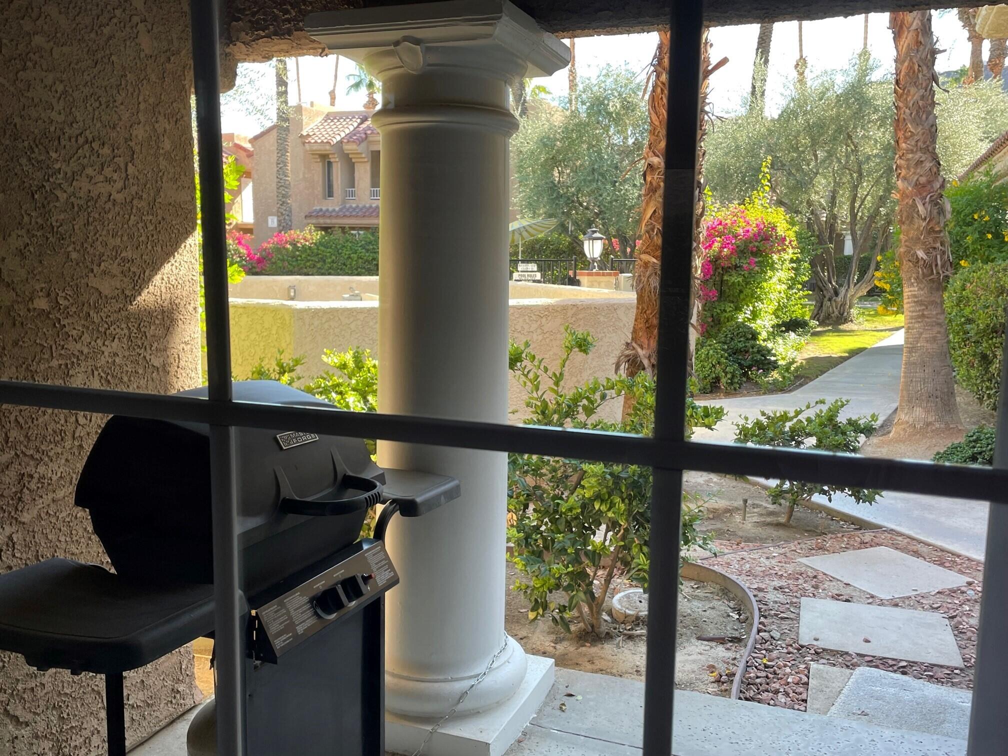 2700 Lawrence Crossley Road, Unit 51 Palm Springs, CA 92264 - Photo 17 of 23 a view of a glass door with a chair in the balcony