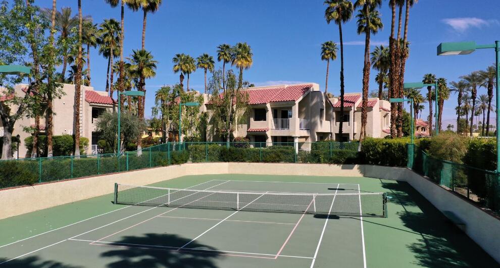 2700 Lawrence Crossley Road, Unit 51 Palm Springs, CA 92264 - Photo 21 of 23 a view of a tennis ground with a large tree in the background