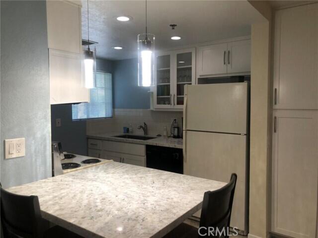 2700 Lawrence Crossley Road, Unit 51 Palm Springs, CA 92264 - Photo 9 of 23 a kitchen with a refrigerator and a stove top oven